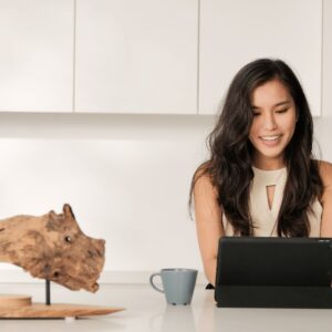 happy girl working on ipad on coffee table